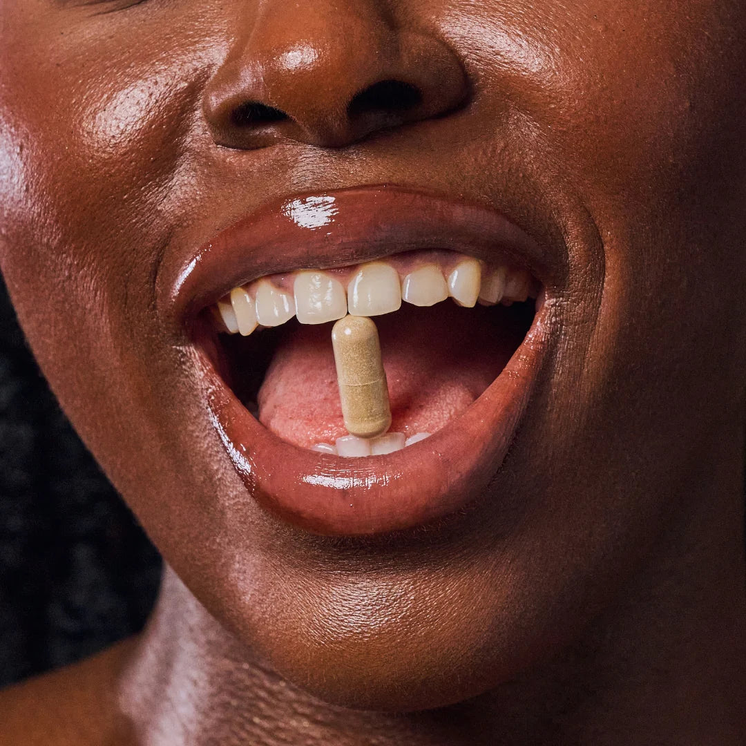 Close-up of a person with a Night Atelier vitamin supplement in their mouth