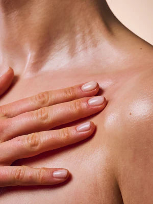 Hand gently touching a shoulder with a focus on skin texture