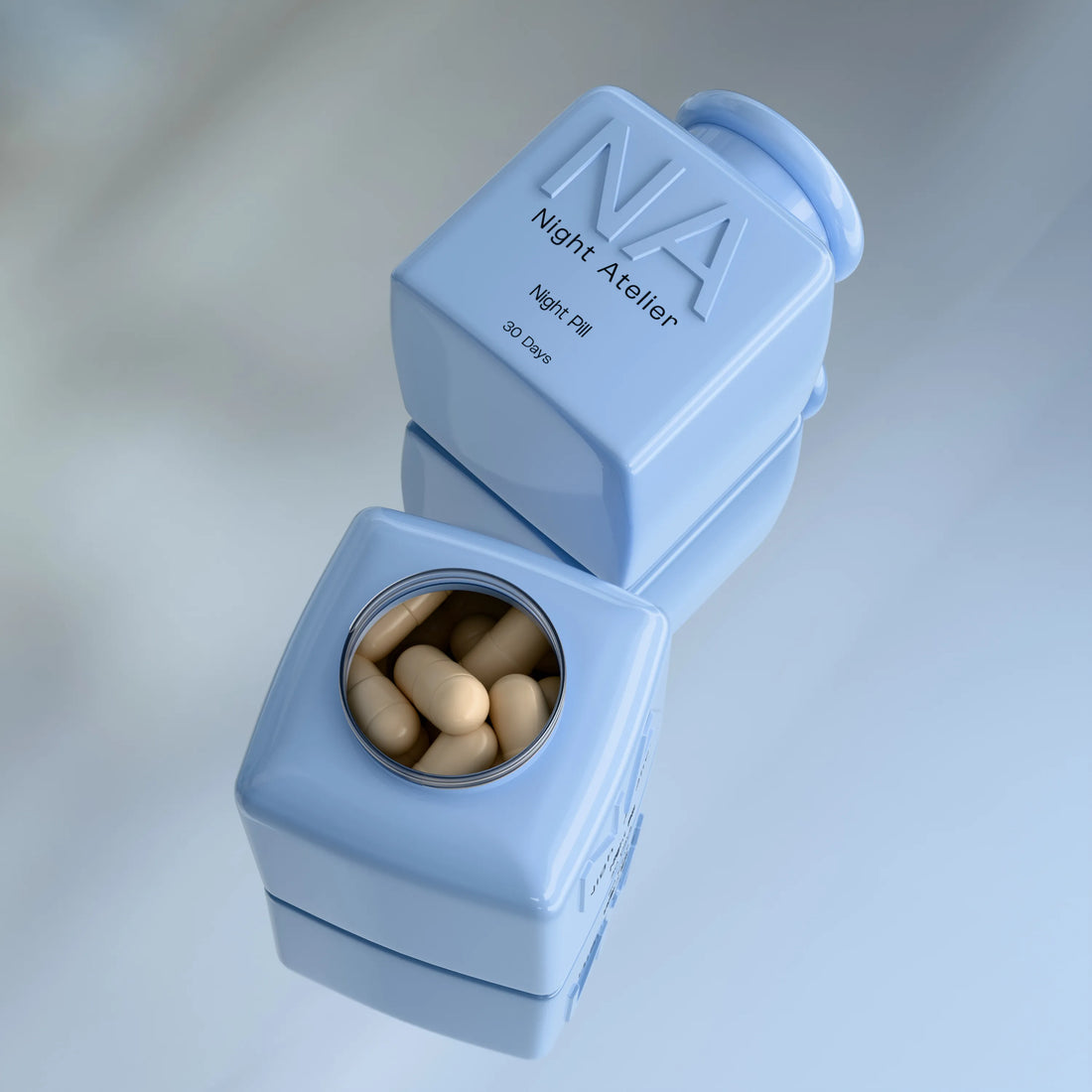 Blue pill organizer with 'Night Atelier' branding and pills inside on a light gray background