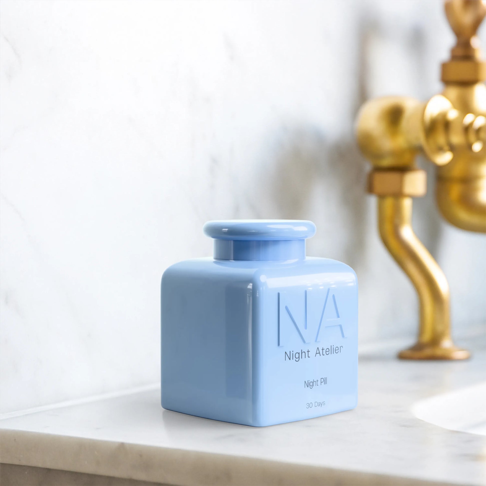 Blue ceramic jar with 'Night Atelier' branding on a marble surface
